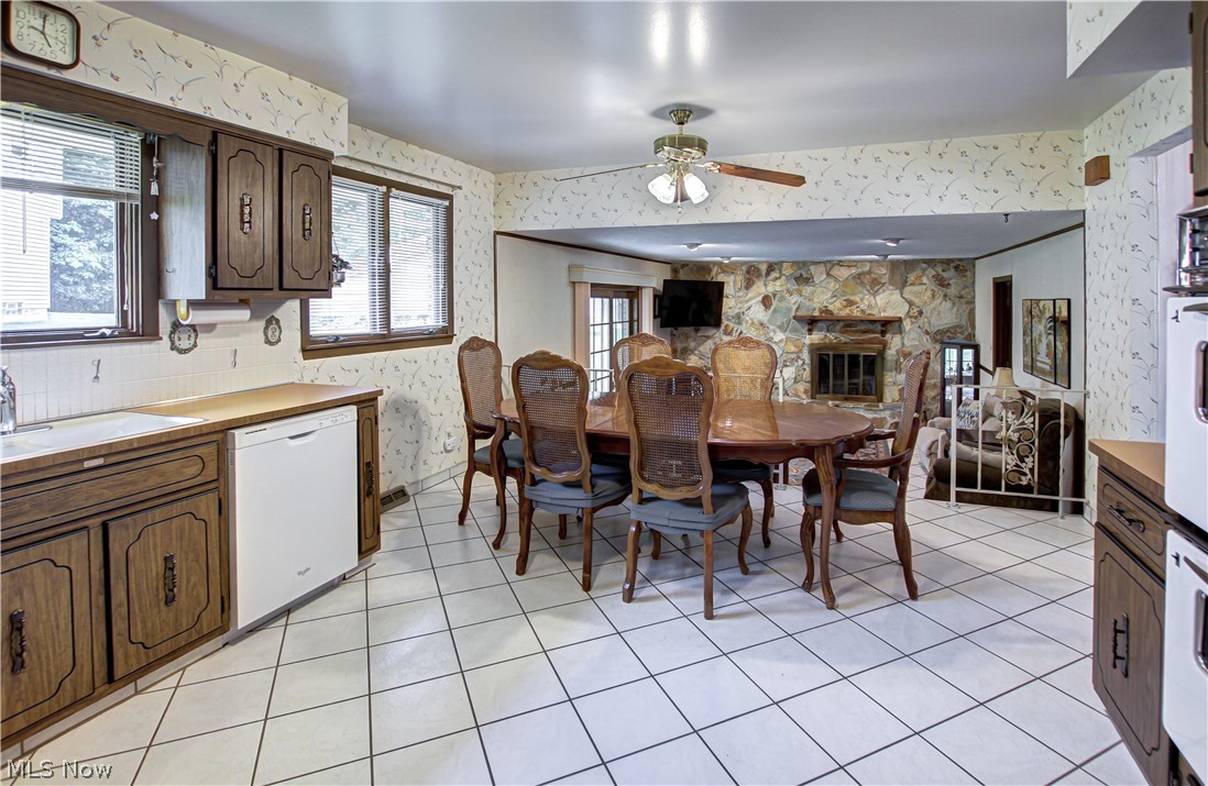 6013 Rousseau Drive Parma, OH 44129 - Photo 6 of 50 Tiled dining space featuring a stone fireplace, sink, and ceiling fan