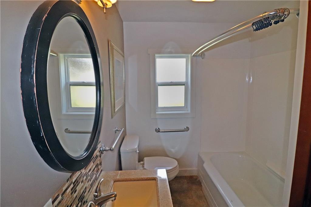 107 Penn Street Greensburg, PA 15601 - Photo 6 of 11 a bathroom with a toilet a sink and a mirror