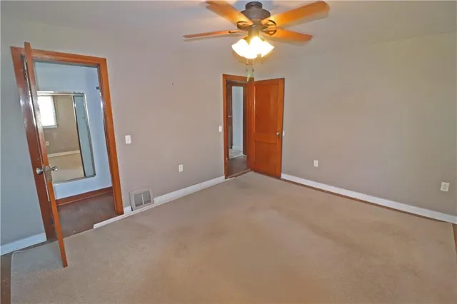 an empty room with a mirror and a fan