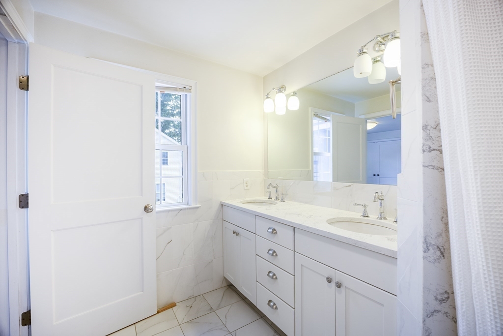 48 Spruce Street, Unit 1 Winchester, MA 01890 - Photo 12 of 29 a bathroom with a double vanity sink and mirror with shower