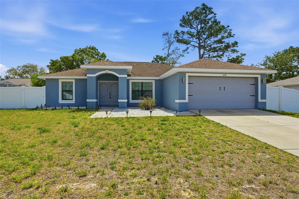 4128 Everett Avenue Spring Hill, FL 34609 - Photo 2 of 57 a front view of a house with a garden and yard