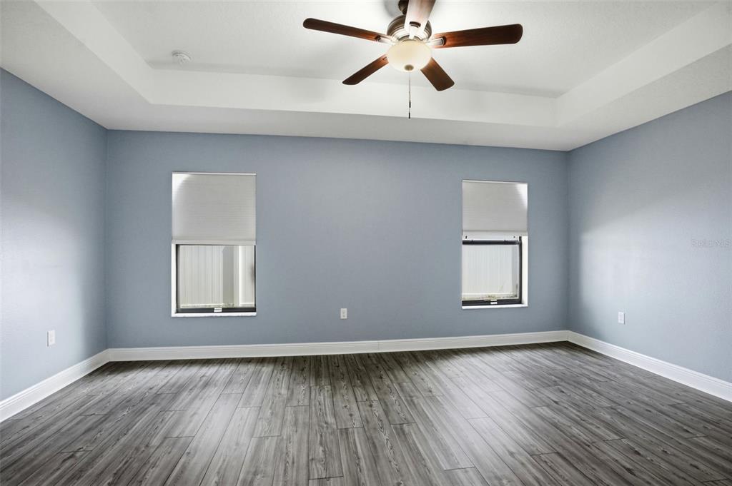 4128 Everett Avenue Spring Hill, FL 34609 - Photo 24 of 57 an empty room with wooden floor chandelier and windows
