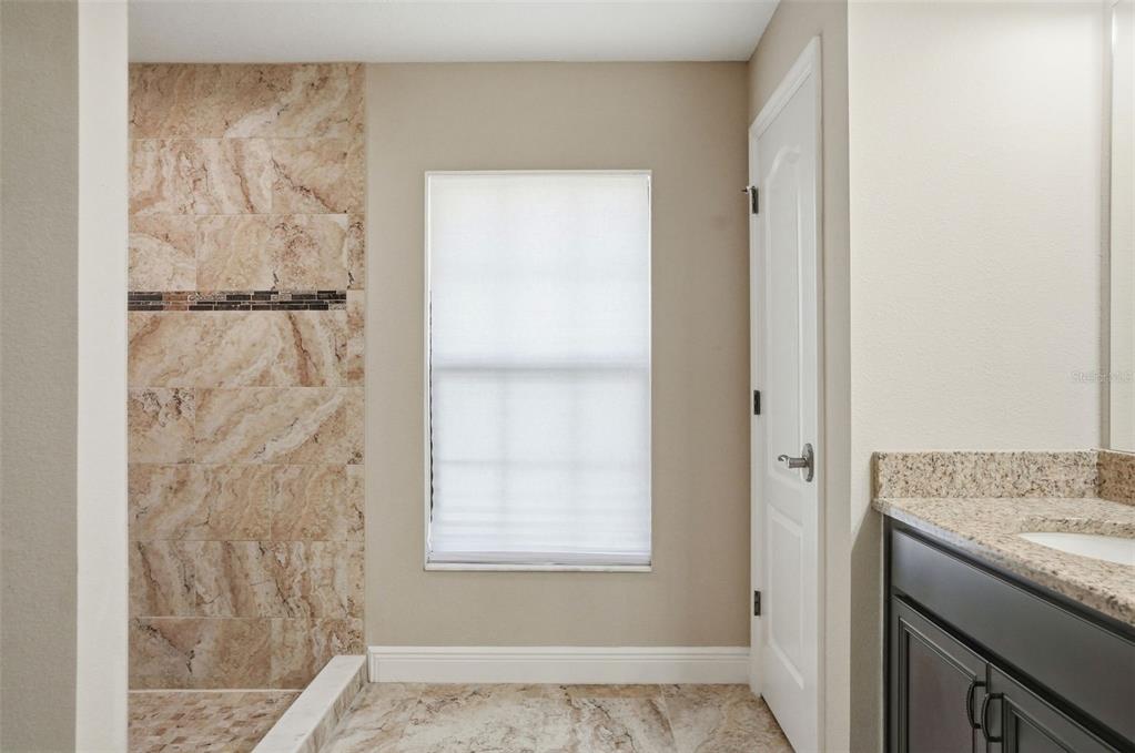 4128 Everett Avenue Spring Hill, FL 34609 - Photo 33 of 57 a bathroom with a granite countertop sink and a shower
