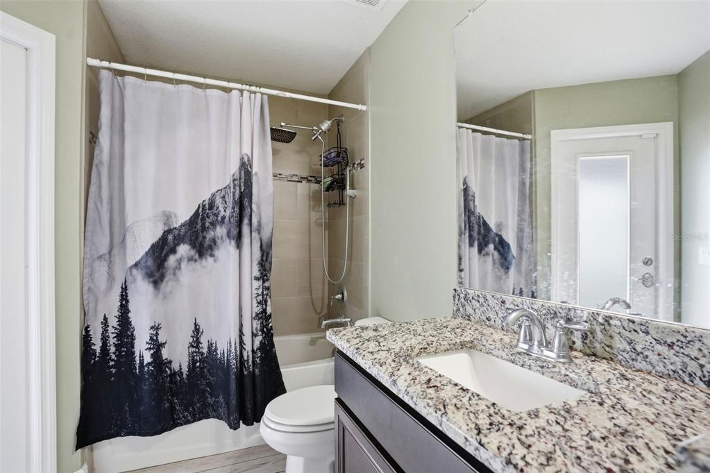 4128 Everett Avenue Spring Hill, FL 34609 - Photo 42 of 57 a bathroom with a granite countertop sink toilet and shower