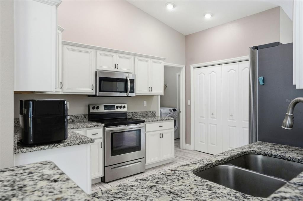 4128 Everett Avenue Spring Hill, FL 34609 - Photo 6 of 57 a kitchen with a stove a microwave and a refrigerator