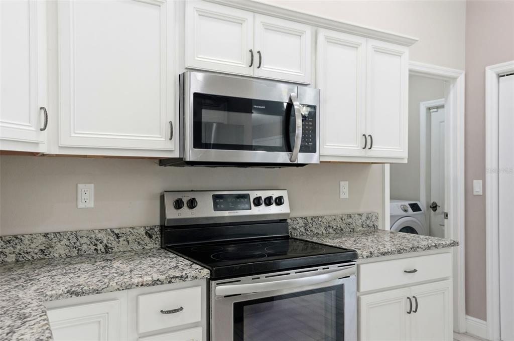 4128 Everett Avenue Spring Hill, FL 34609 - Photo 8 of 57 a kitchen with granite countertop white cabinets stainless steel appliances and a counter space