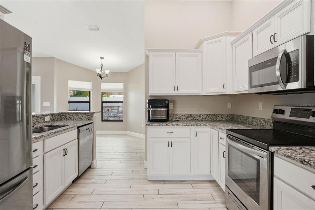 4128 Everett Avenue Spring Hill, FL 34609 - Photo 9 of 57 a large kitchen with stainless steel appliances granite countertop a stove and a sink