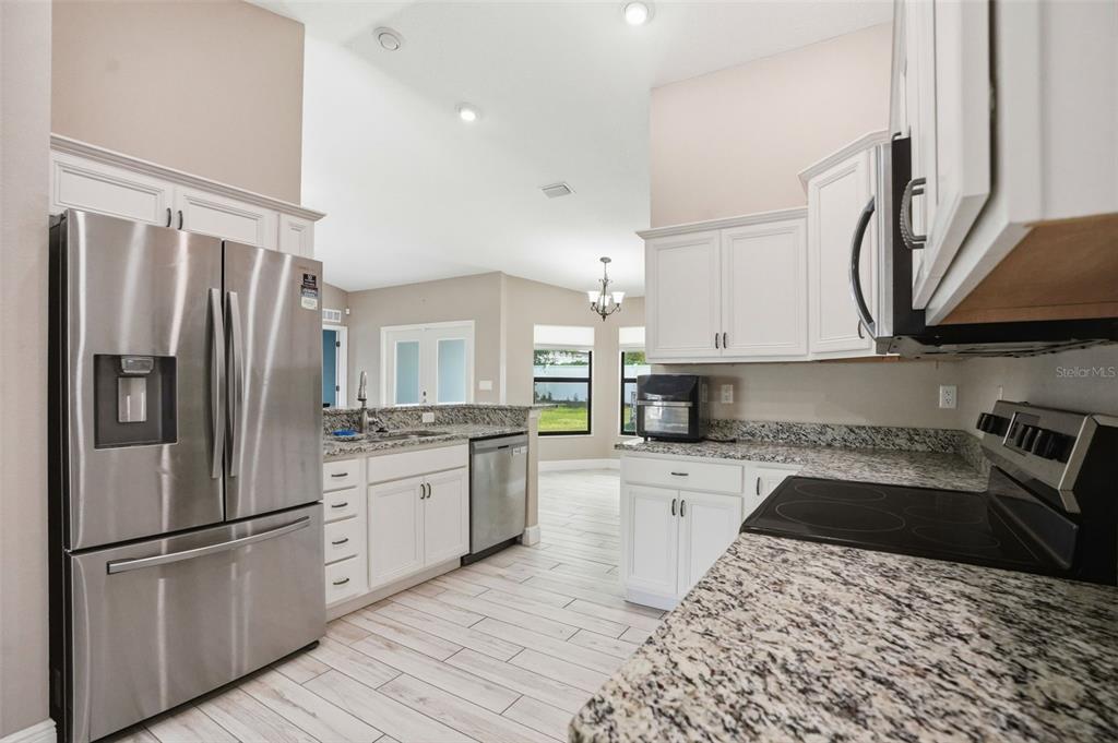 4128 Everett Avenue Spring Hill, FL 34609 - Photo 10 of 57 a kitchen with stainless steel appliances granite countertop a refrigerator a stove a sink and a microwave