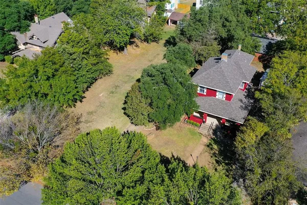 an aerial view of residential house with outdoor space and trees all around