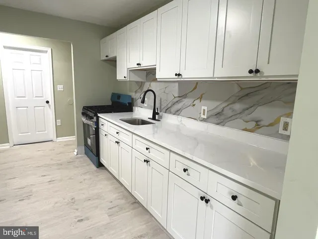 a kitchen with stainless steel appliances granite countertop a sink and dishwasher with white cabinets