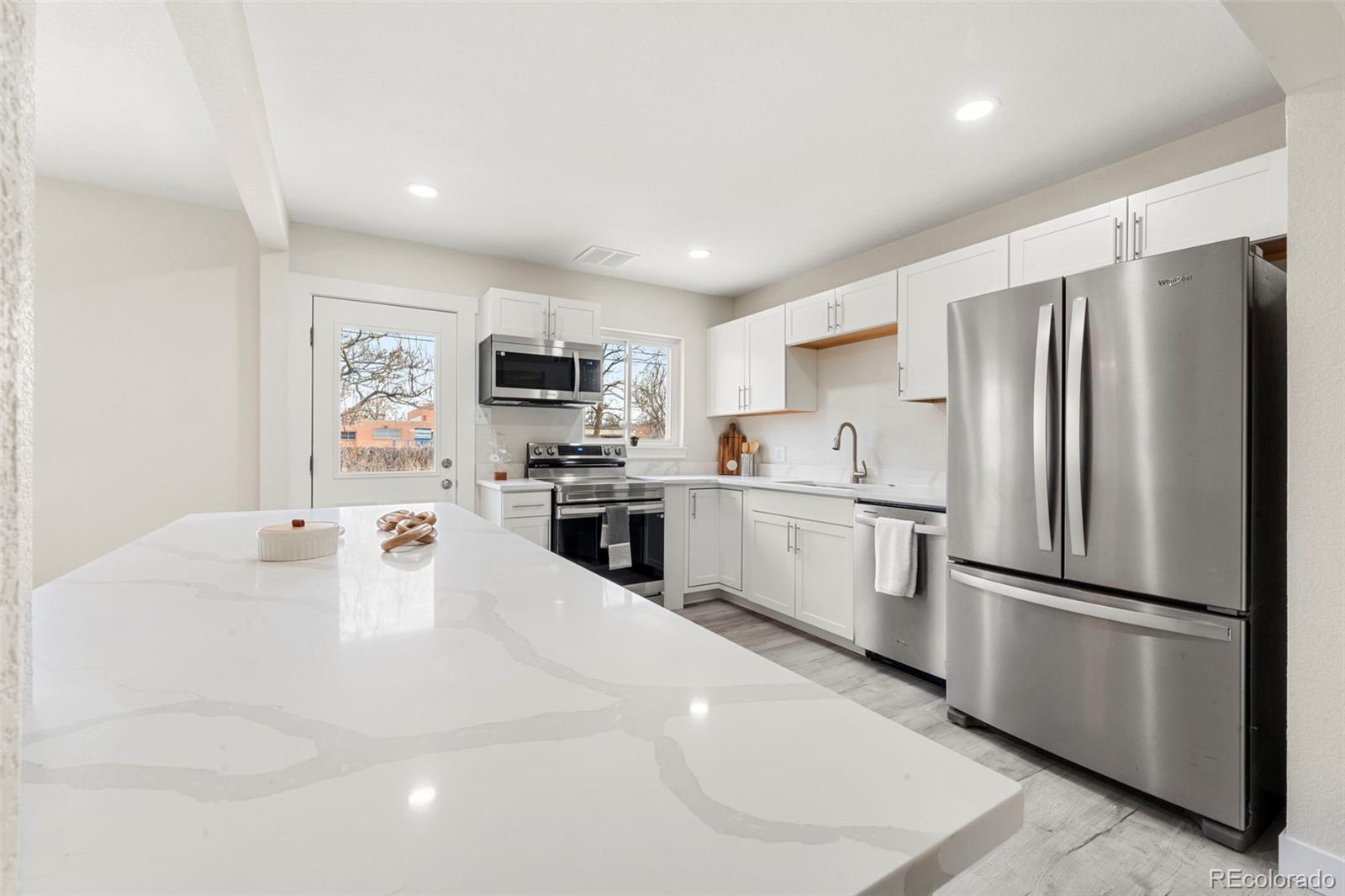 a kitchen with white cabinets and stainless steel appliances