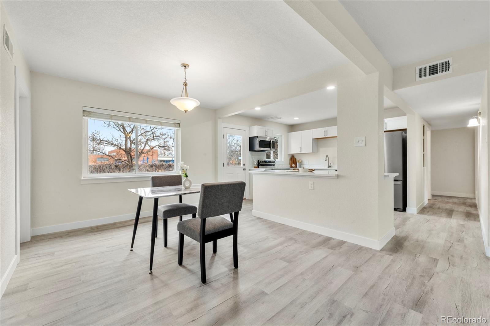 1216 Ursula Street Aurora, CO 80011 - Photo 11 of 30 a view of a dining room with furniture window and wooden floor