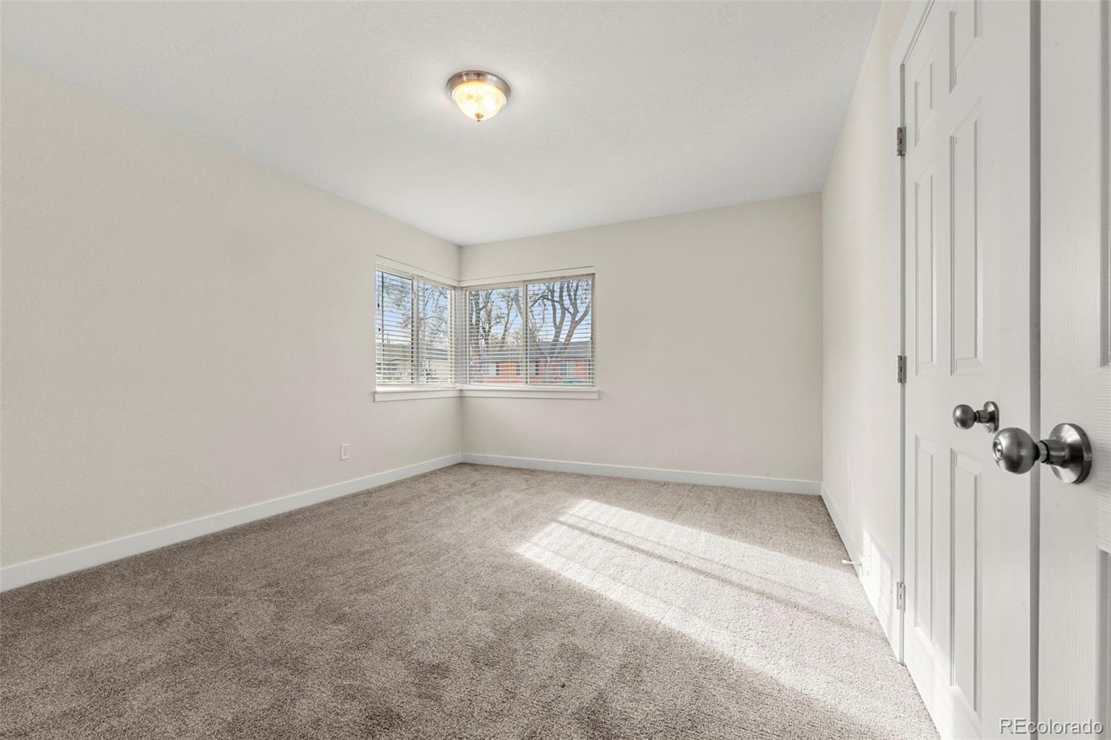 1216 Ursula Street Aurora, CO 80011 - Photo 15 of 30 an empty room with windows and closet