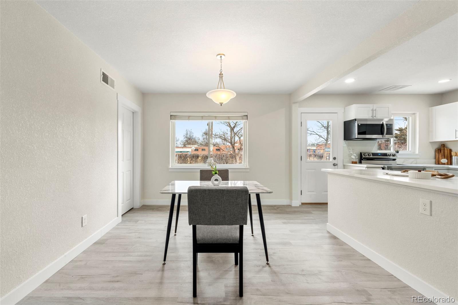 1216 Ursula Street Aurora, CO 80011 - Photo 10 of 30 a view of a dining room with furniture window and wooden floor