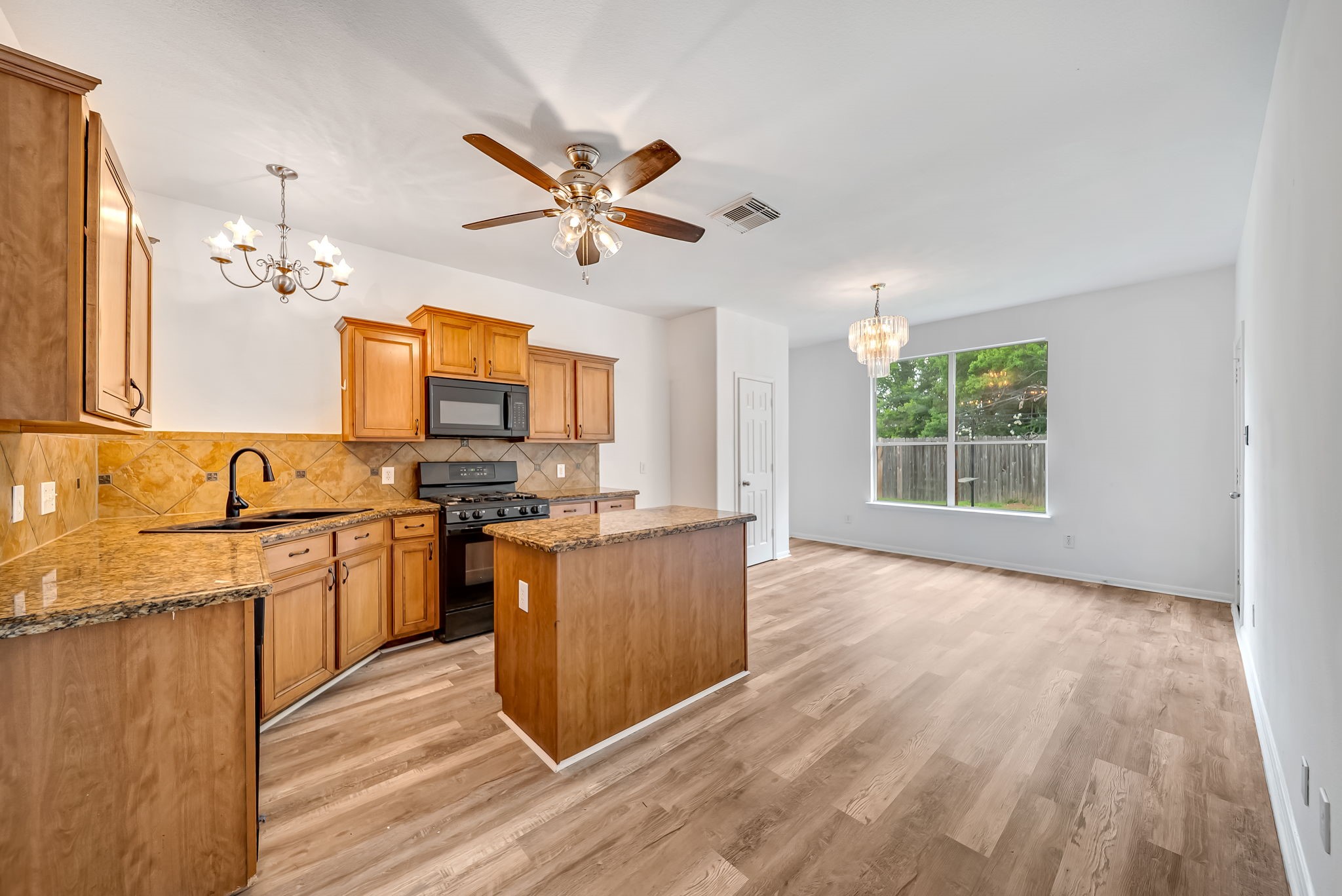 23526 Whispering Maple Drive Spring, TX 77373 - Photo 6 of 26 a view of a kitchen with a sink wooden floor and a window