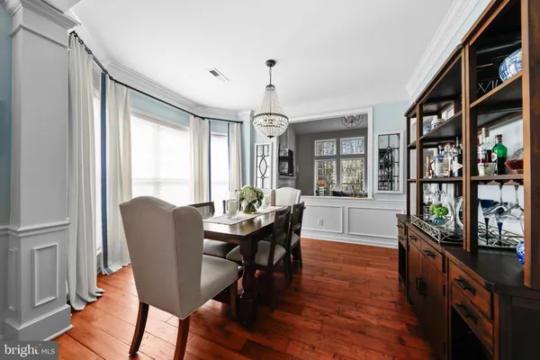 a dining room with furniture window and wooden floor