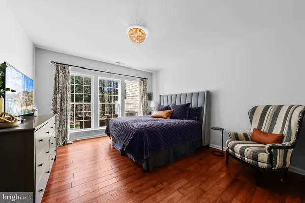 a spacious bedroom with a bed and wooden floor