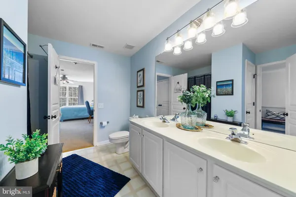 a bathroom with a granite countertop sink a toilet and mirror