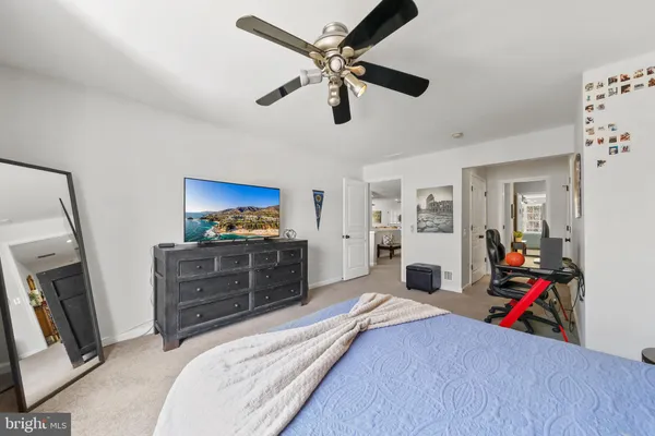 a bedroom with a bed and a mirror on the dresser
