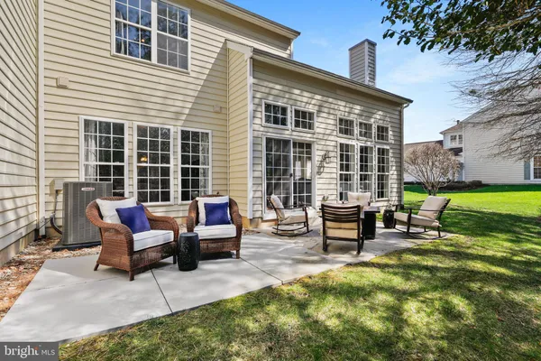 a backyard of a house with a bench and chairs