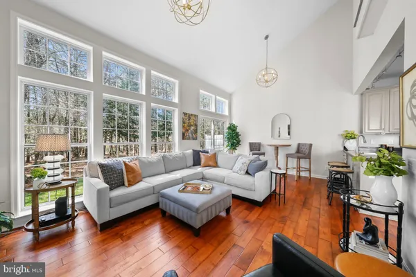 a living room with furniture large window and wooden floor