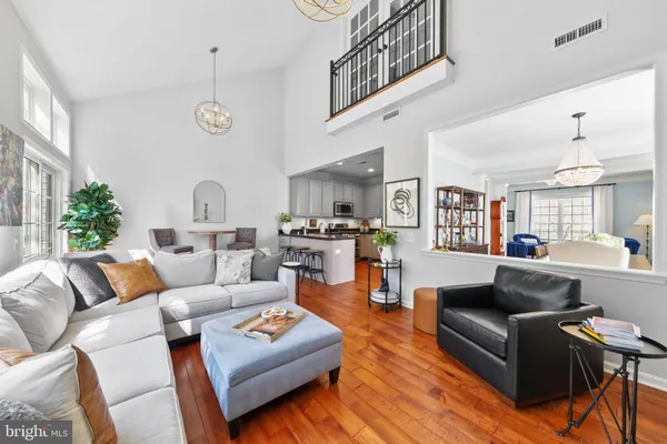 a living room with furniture kitchen view and a large window