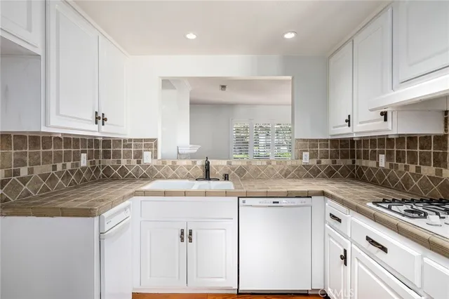 a kitchen with kitchen island granite countertop a sink and cabinets