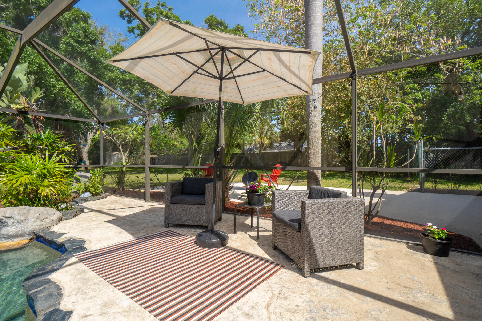 810 Knecht Road Northeast Palm Bay, FL 32905 - Photo 20 of 63 a view of a patio with couches and chairs under an umbrella