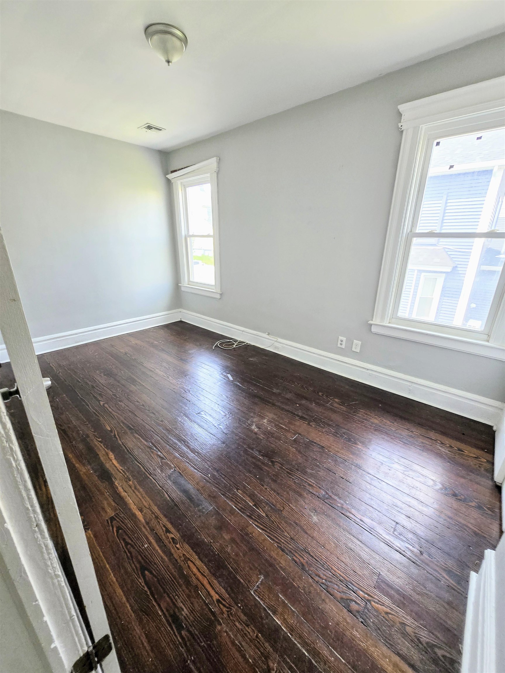 316 Devon Street, Unit 2 Kearny, NJ 07032 - Photo 8 of 9 an empty room with wooden floor and windows