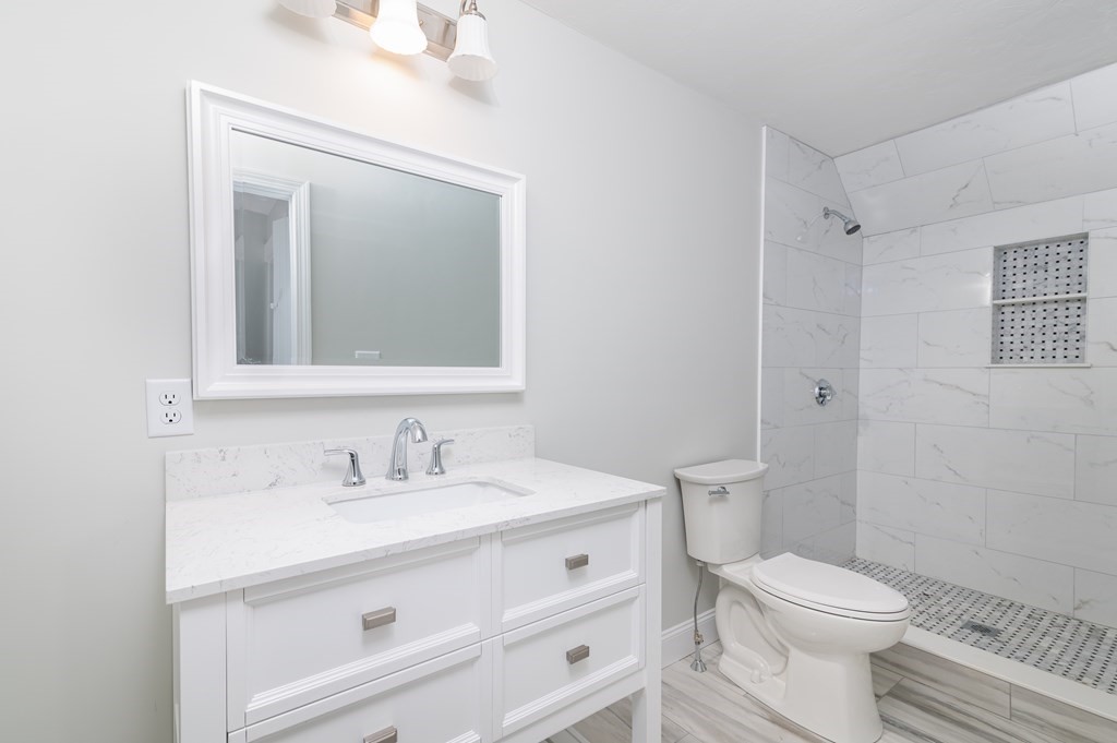 36 Cherry Street Whitman, MA 02382 - Photo 17 of 35 a bathroom with a toilet a sink a vanity and mirror