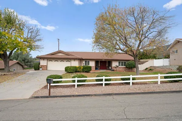 a view of a house with a yard and large tree
