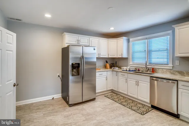 a kitchen with granite countertop a refrigerator and a sink