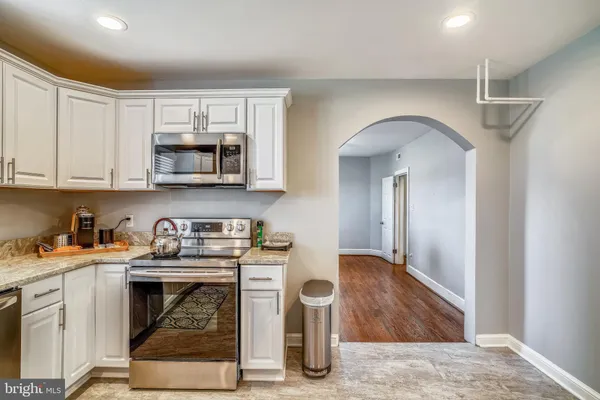 a kitchen with stainless steel appliances granite countertop a stove a microwave and cabinets