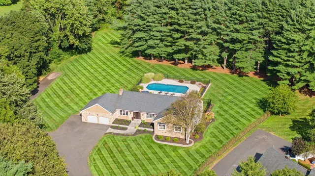 an aerial view of a house with a yard basket ball court and outdoor seating