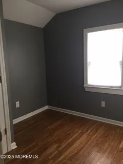 a view of a small space with wooden floor and a window