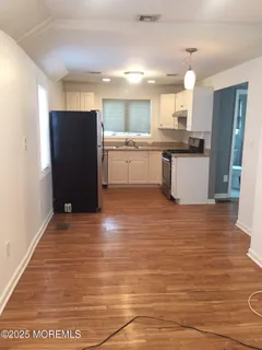 a kitchen with stainless steel appliances kitchen island granite countertop a refrigerator and a sink