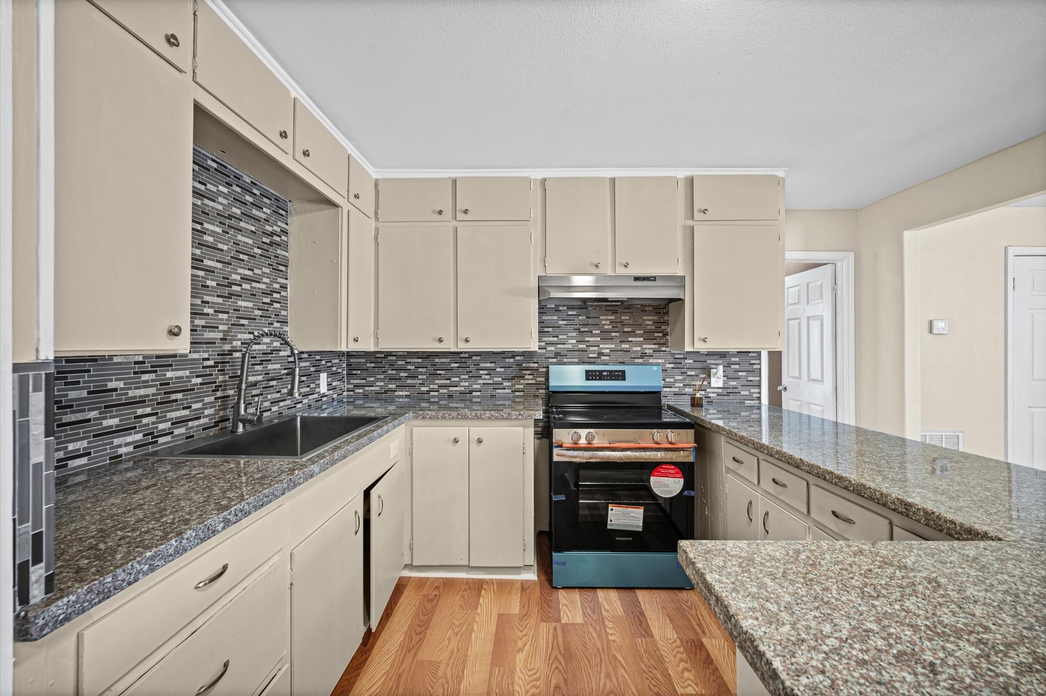 10621 Lane Street Houston, TX 77029 - Photo 7 of 29 a kitchen with granite countertop a stove top oven and cabinets
