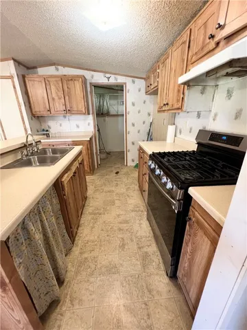 a kitchen with granite countertop a stove and a sink