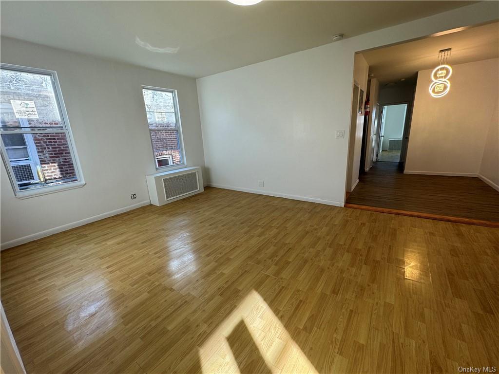a view of empty room with window and wooden floor