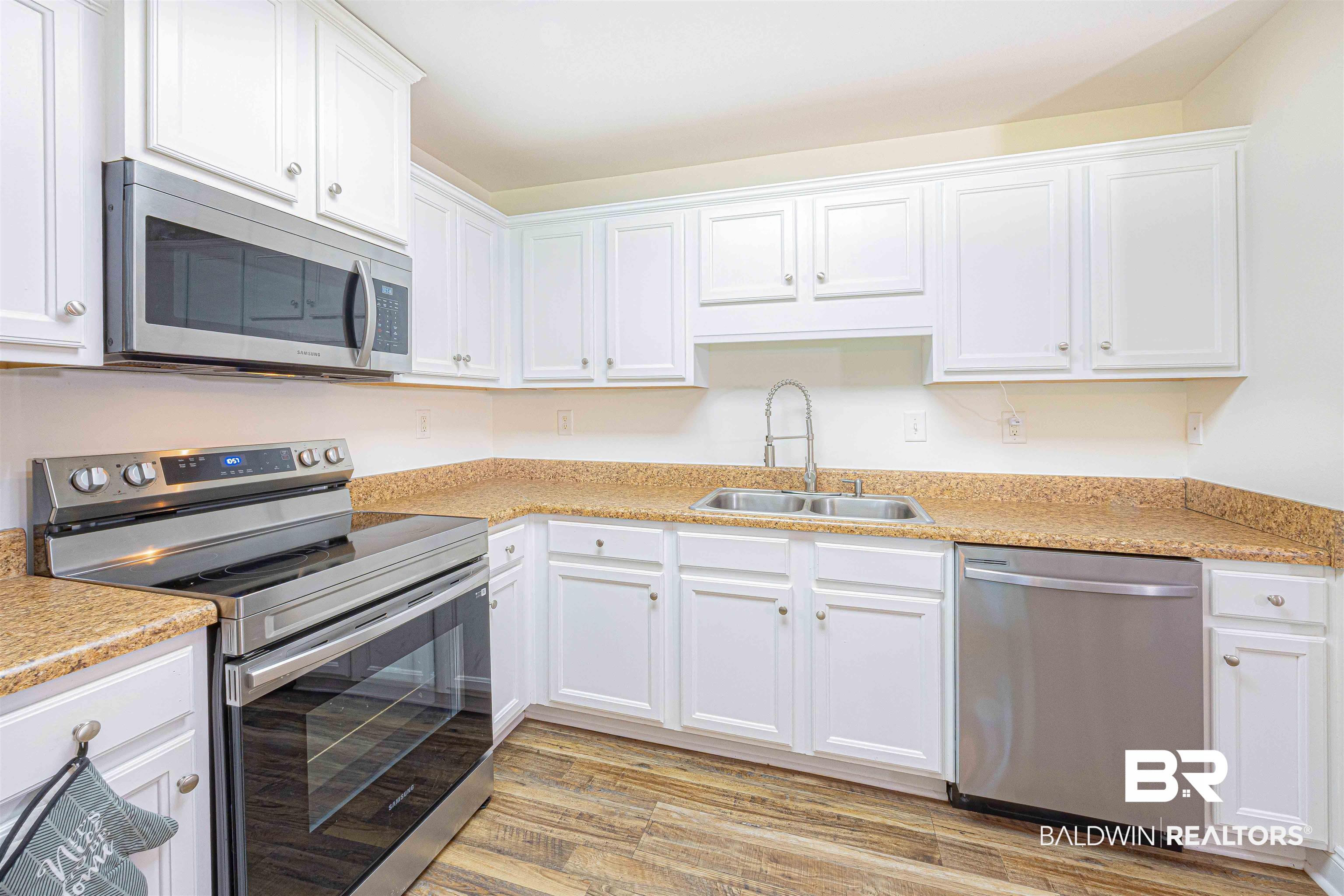 18675 Explorer Drive Loxley, AL 36551 - Photo 13 of 42 Kitchen with appliances with stainless steel finishes, a sink, white cabinets, and light wood-style flooring