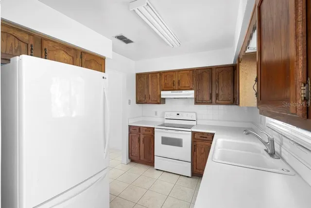 a kitchen with stainless steel appliances a refrigerator sink and stove