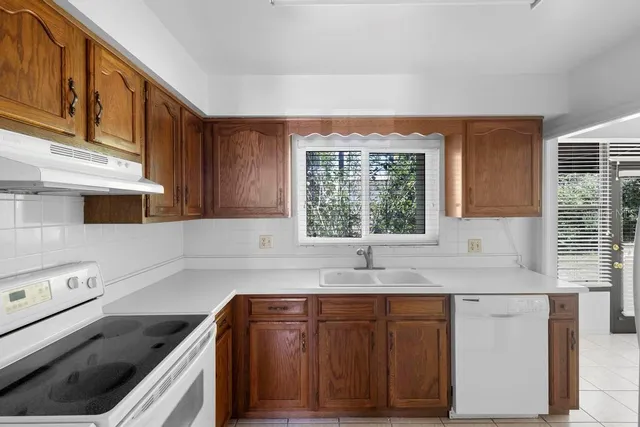 a kitchen with granite countertop cabinets sink and window