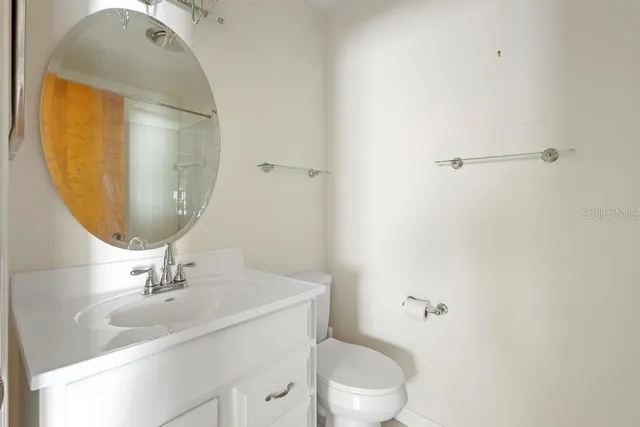 a bathroom with a sink mirror vanity and toilet