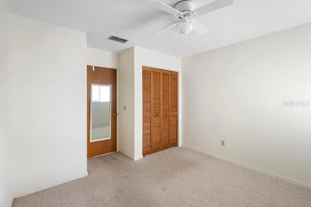 an empty room with a ceiling fan and a window