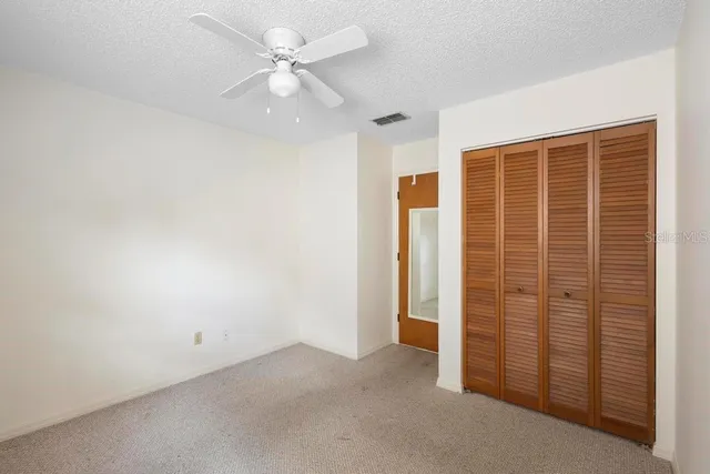 en empty room with windows and ceiling fan