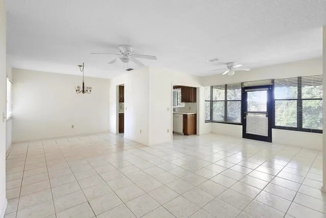 an empty room with windows and fireplace
