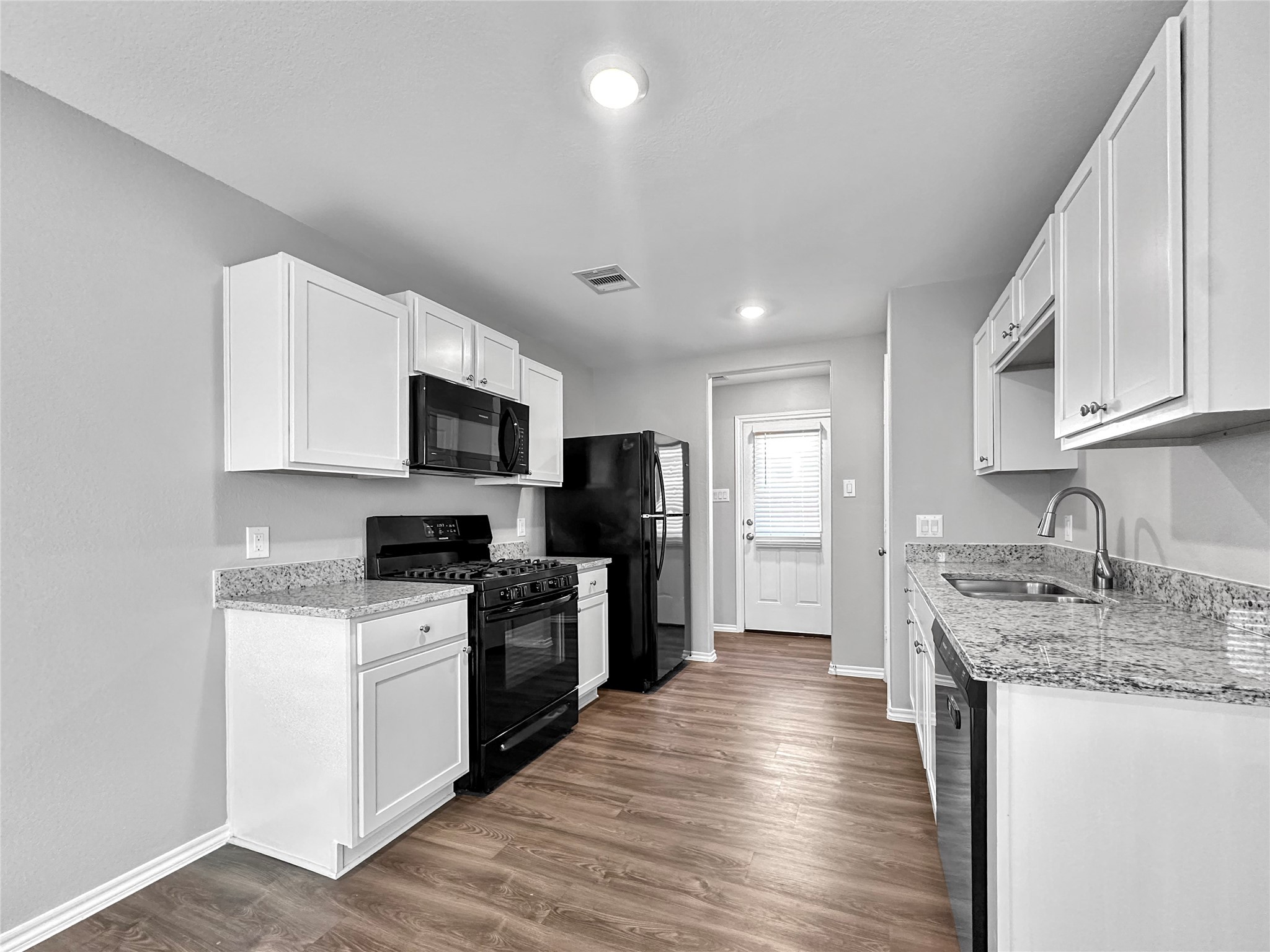 937 Silver Birch Branch Magnolia, TX 77354 - Photo 6 of 19 a kitchen with granite countertop a sink wooden floor and stainless steel appliances