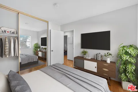 a bedroom with a bed and a flat screen tv