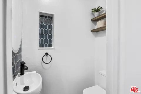a bathroom with a sink toilet and mirror