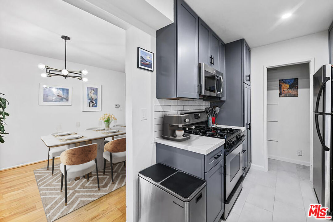 5825 Bowcroft Street, Unit 1 Los Angeles, CA 90016 - Photo 6 of 20 a kitchen with stainless steel appliances granite countertop a stove top oven a sink dishwasher and a refrigerator with wooden floor